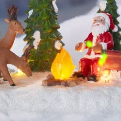 Père Noël et ses rennes au coin du feu lumineux village